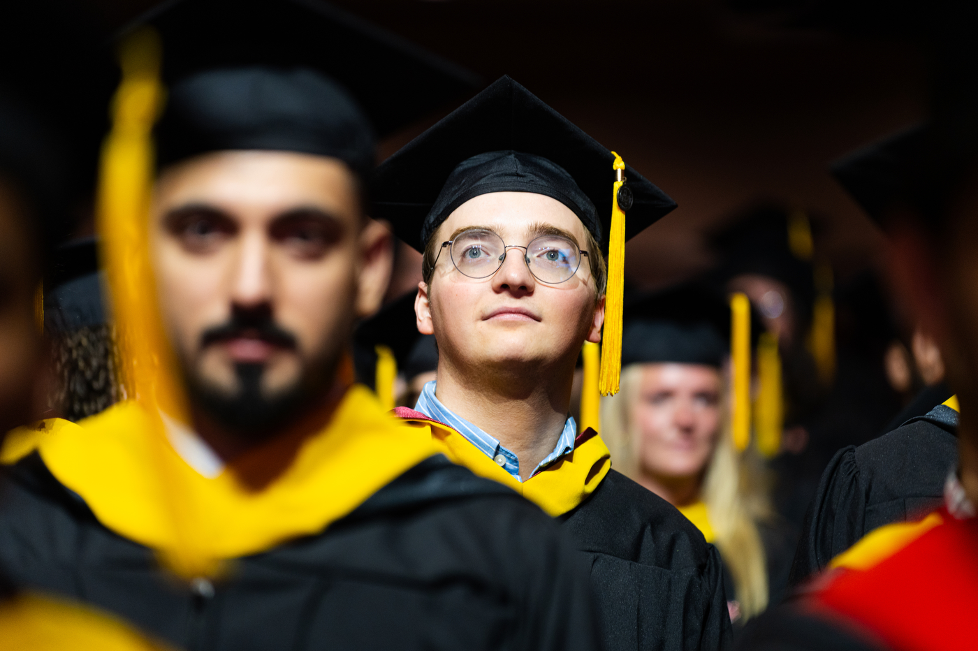 Graduates in caps and gowns listen during the Northeastern commencement in Portland.