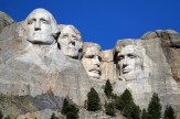 Mount Rushmore depicted under a cloudless blue sky.