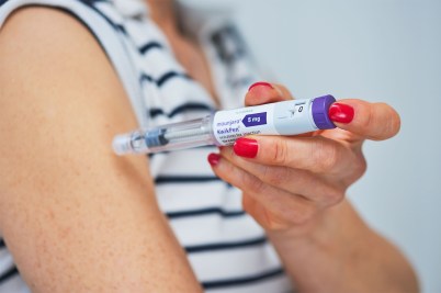 A person uses an injection pen labeled Mounjaro.
