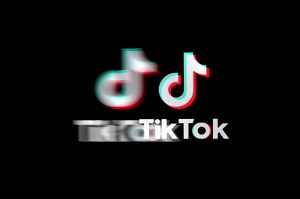 A stylized TikTok logo appears blurry and distorted on a black background.