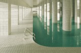 A surreal 3D-rendered image of a tiled indoor pool with columns and shadows.