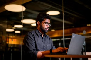 Sai Panindra Santosh Kumar Majji sitting at a desk working at a laptop.