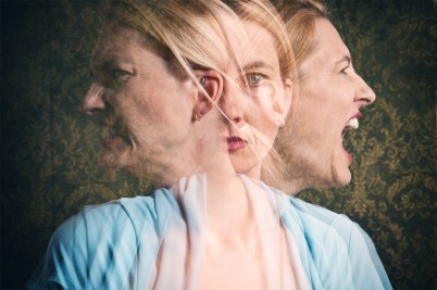 A surreal image of a woman in a blue shirt battling inner feelings, visualized to her left and right.