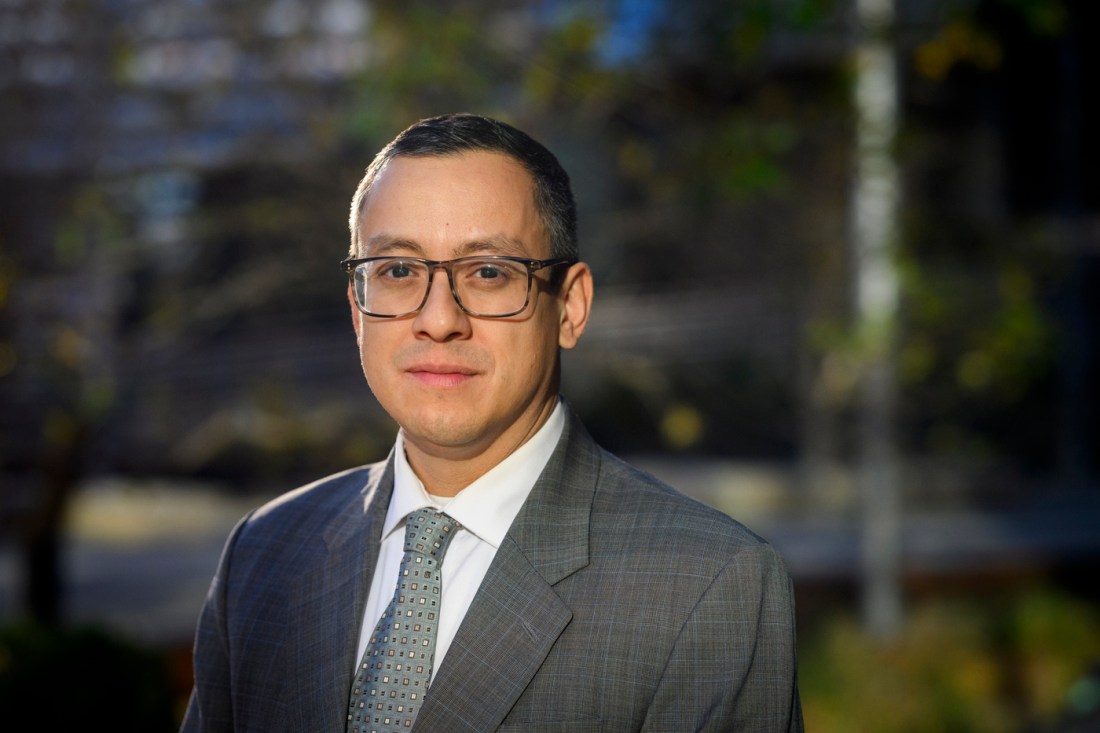 Portrait of Eric Piza, wearing a suit and tie outside