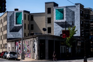 Optical illusions painted on the side of a brick building.
