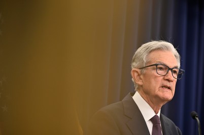 A side view of Jerome Powell speaking at a press conference.