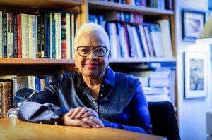 A portrait of Margaret Burnham, who is wearing a blue shirt, set against a bookshelf.