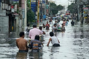 Residents in the Philippines are shown wading through a flooded road in the aftermath of a typhoon.