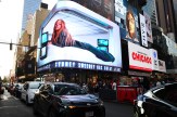 A billboard above American Eagle depicting a prone Sydney Sweeney.