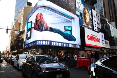 A billboard above American Eagle depicting a prone Sydney Sweeney.