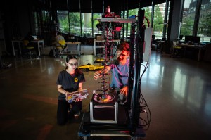 Two students sit behind SCCRUB cleaning robot.