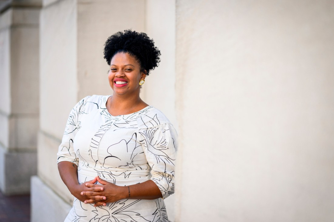 A portrait of Beyazmin Jiménez, shown in a white dress and leaning against a wall.