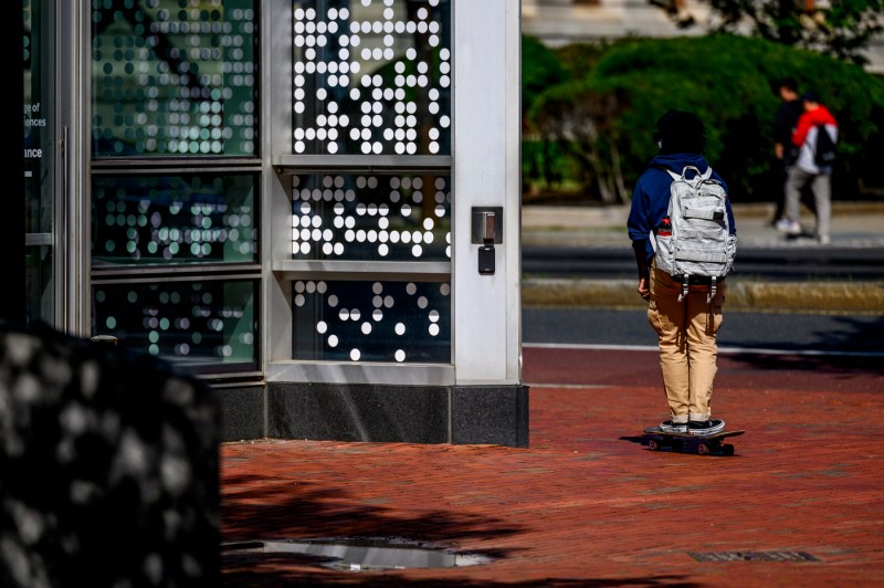 A person rides on a skateboard on the Boston campus. 