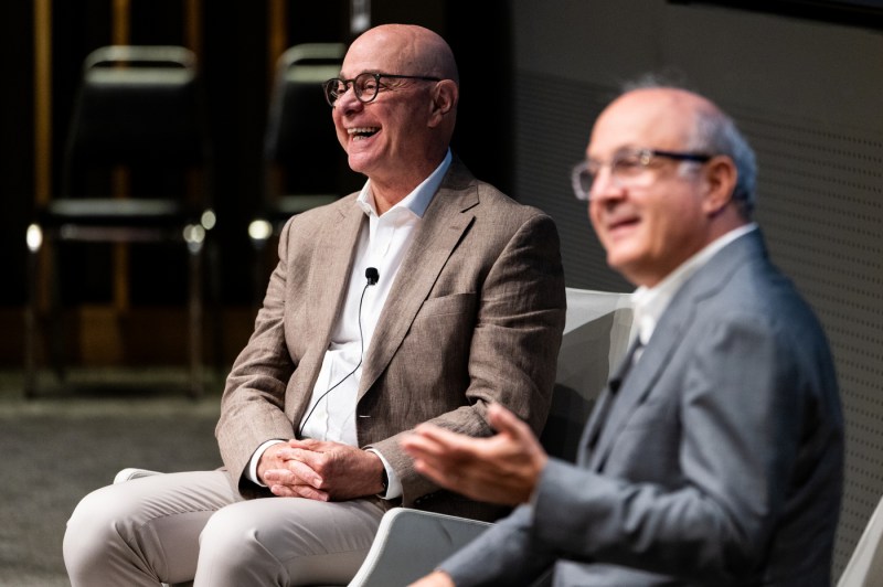 Joseph Aoun shares a laugh with the other speaker while seated on stage during a fireside chat at Northeastern University’s Senior Leadership Retreat in the ISEC auditorium.