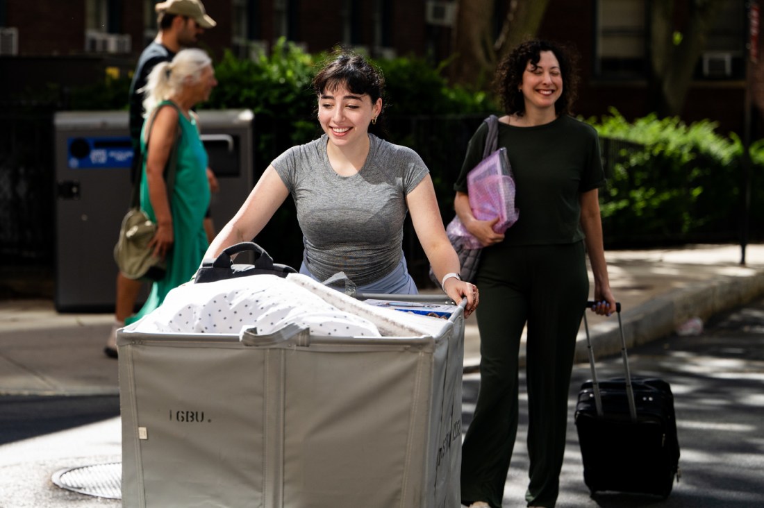 A family smiles while moving their students belongings.