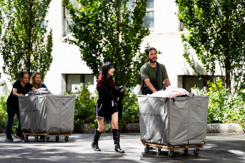 People push hampers full of move-in supplies.