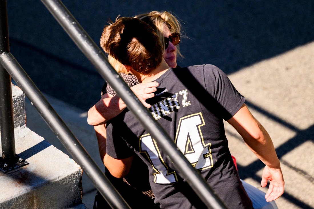 A mother hugs her son next to a stairwell on Northeastern's Boston campus.