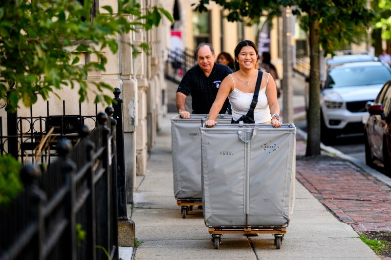 People push hampers full of move-in supplies.