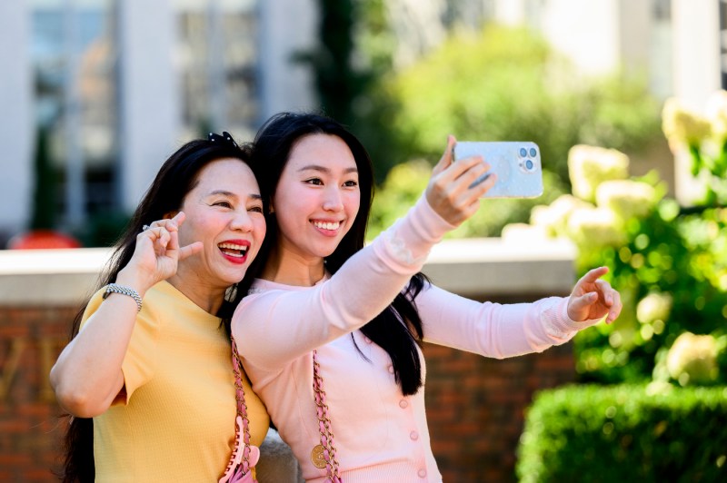 Two people smile for a selfie on the Boston campus.
