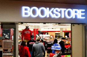 The Northeastern Bookstore with the sign lit up and an array of clothing displayed inside.