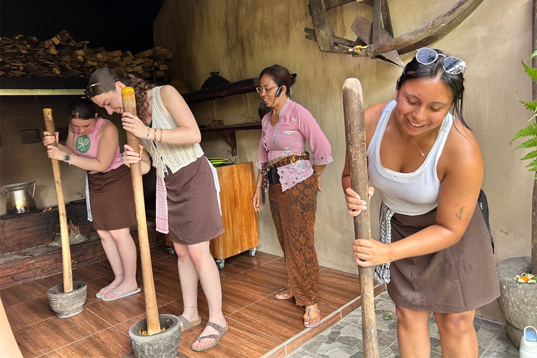 Students are lead by and instructor in using a standing mortal and pestle.