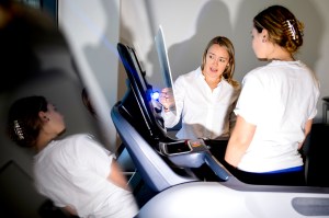 Lauren Raine, an assistant professor at Northeastern, shown directing a female student to information on a screen.