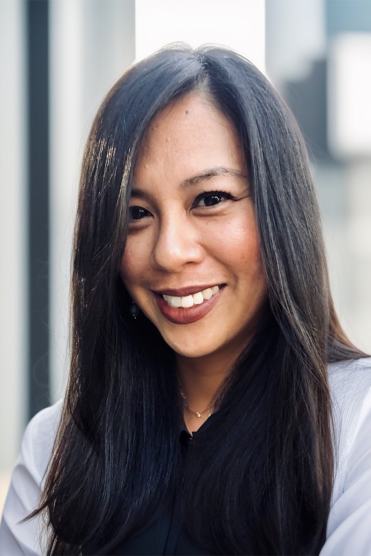 A portrait of Girlie Delacruz smiling.