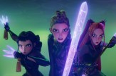A screen capture from the movie K-pop Demon Hunters that shows three animated characters posing against a green background, each wielding glowing purple weapons.