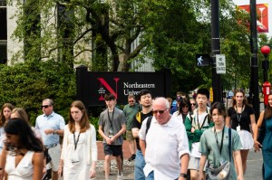 A diverse crowd of people walks through Northeastern's Boston campus on a tour.
