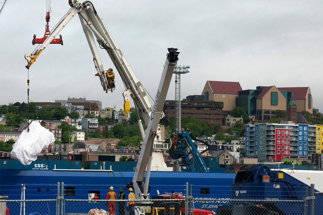 A piece of the Titan submersible being craned out of the water.