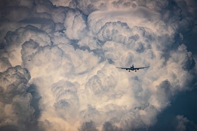 Two airplanes approaching to land against a background of storm clouds.