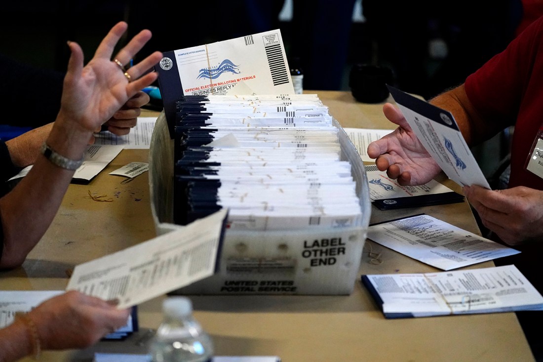 Election workers shown counting ballots.
