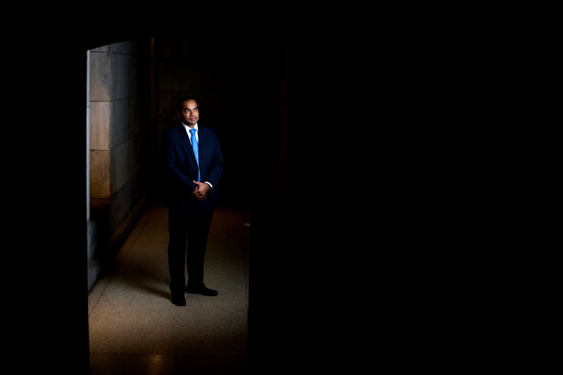 Ganesh Thakur shown in a suit in a dark corridor.