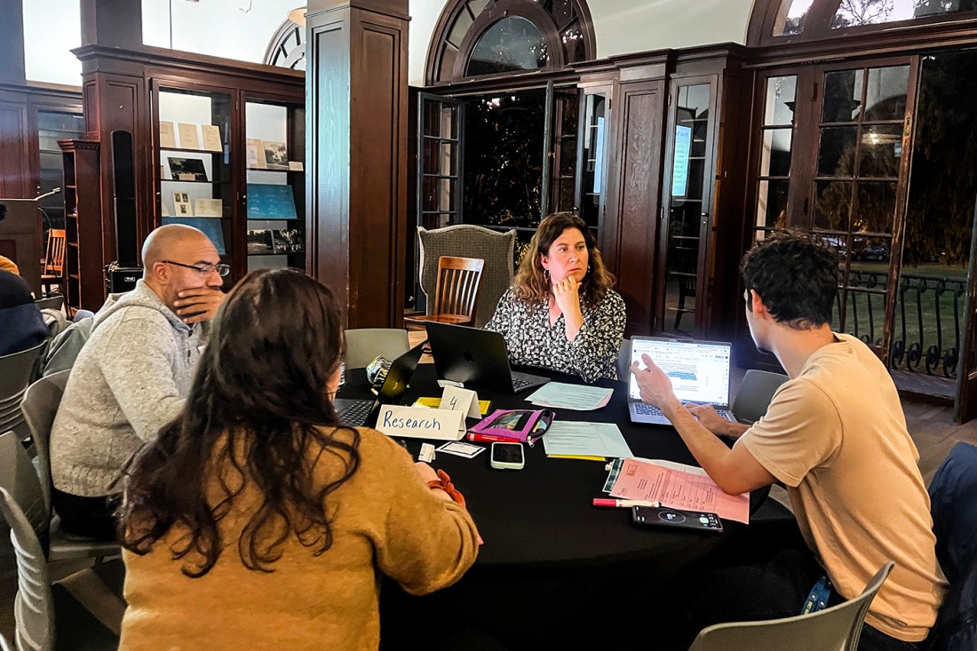 A group of students or teachers sitting around a table engaged in conversation.