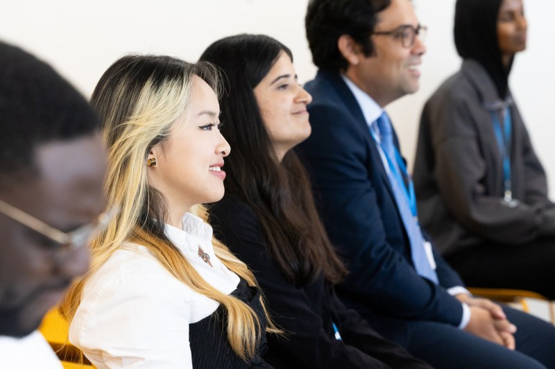 Students at Northeastern’s London campus smile while attending a graduation ceremony for the digital skills program in partnership with The Diana Award and ServiceNow.