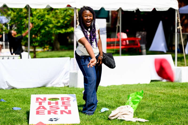 A student plays corn hole outside.