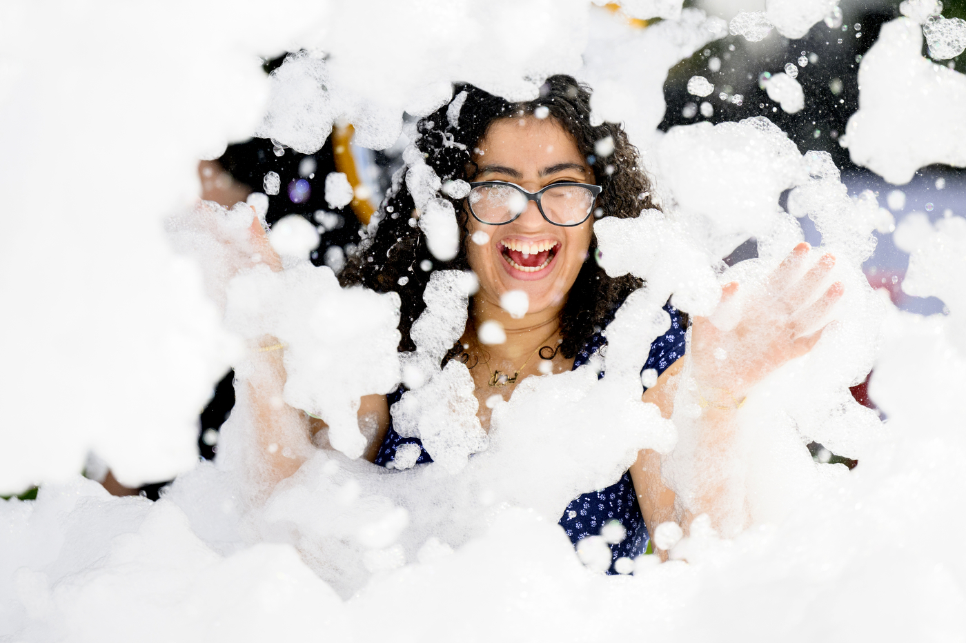A student smiles while playing in the foam party.