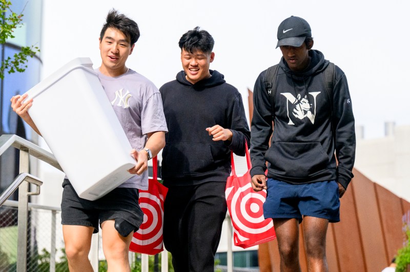 Student carry Target shopping bags and a trash barrel.
