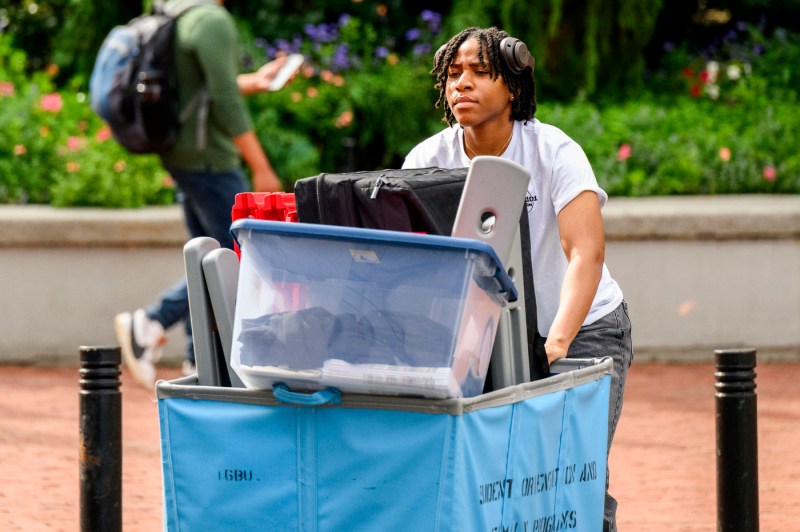A student pushes a move-in hamper. 