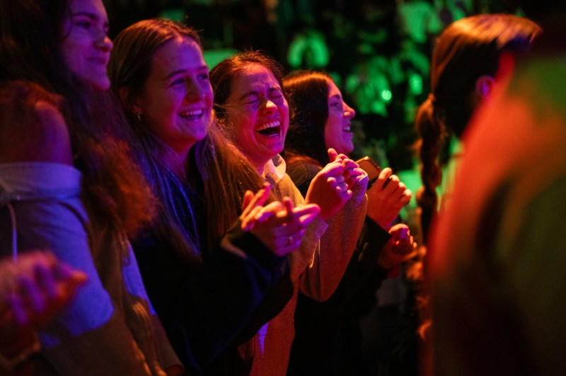 The crowd at convocation laughs. 