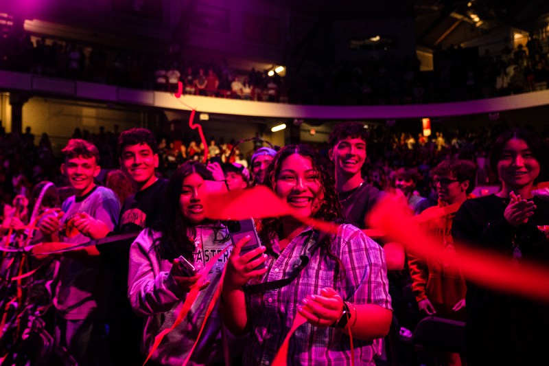 The crowd at convocation smiles while the streamers fly through the air.