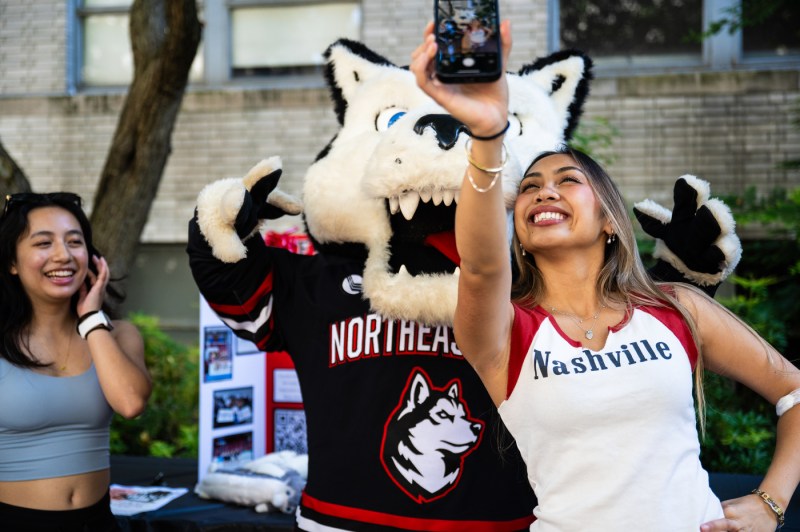 A student poses for a selfie with Paws.