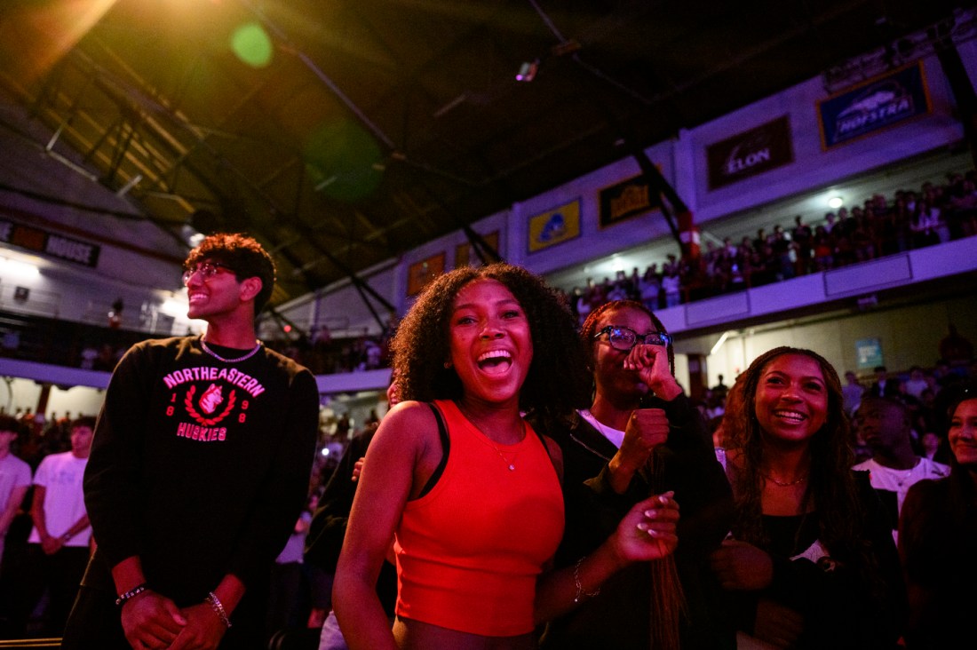 Students in the arena cheer and laugh during the convocation event.