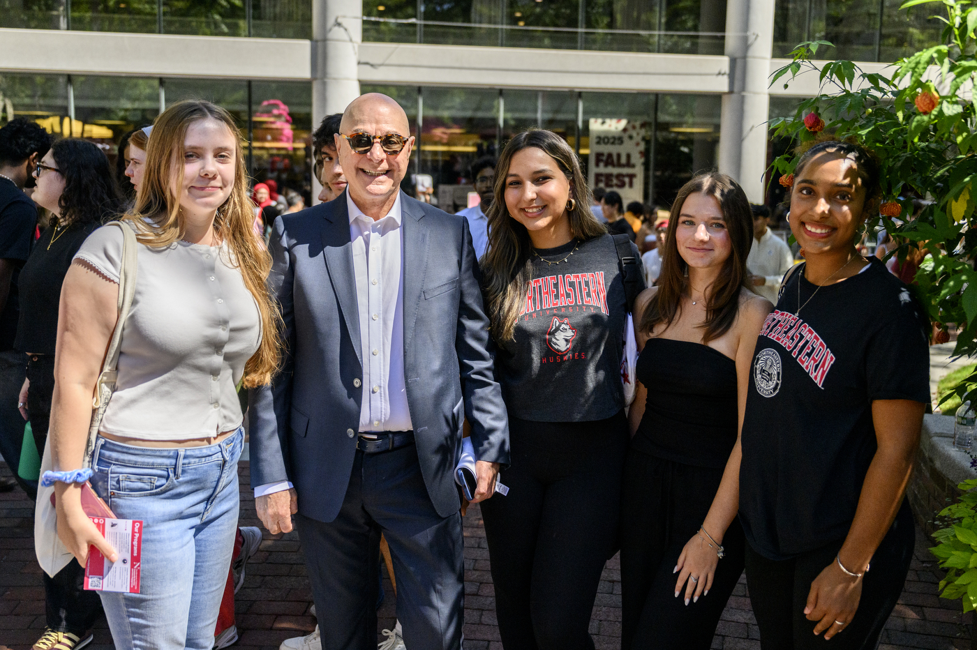 President Aoun smiles for a photo with a group of students.