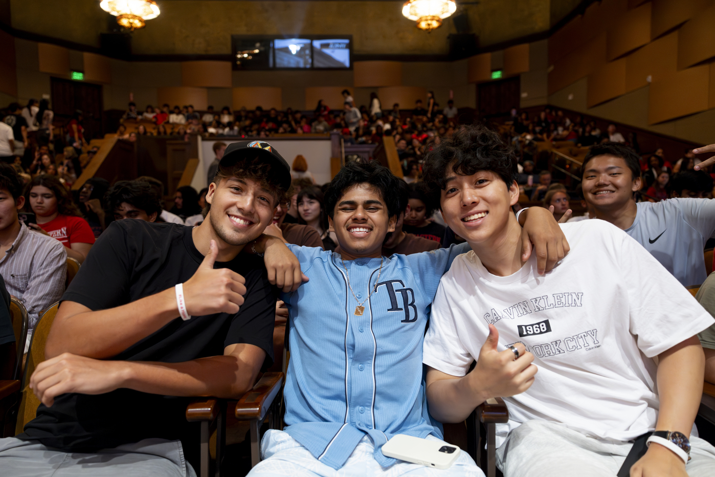 Three students with their arms around each other pose for a photo at the Oakland convocation. 