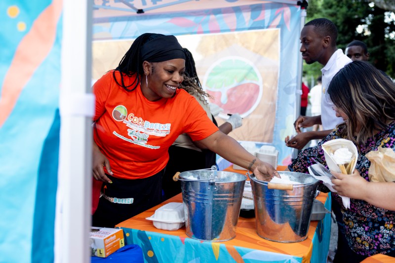 A person serves food at Taste of Oakland.