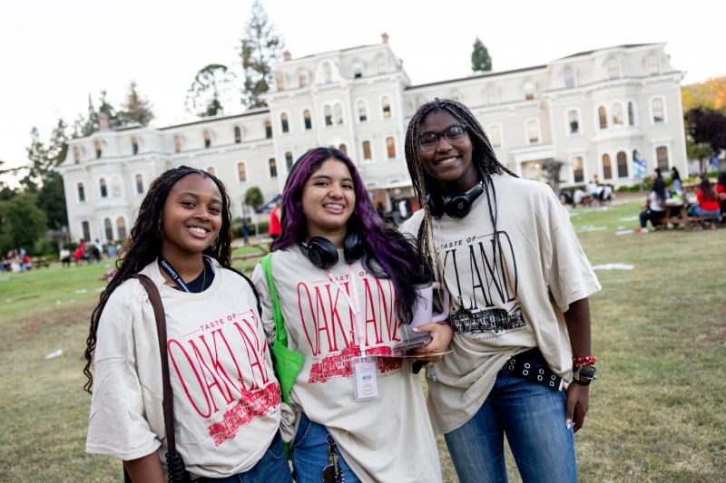 Three students smile for a photo on the Oakland campus.