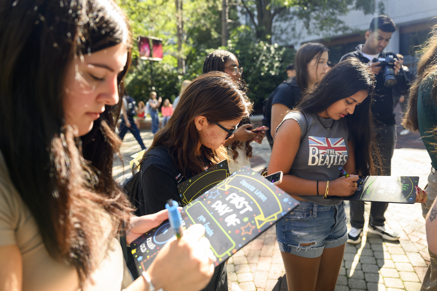 Students fill out "First Day of School" blackboards with their names and ages. 