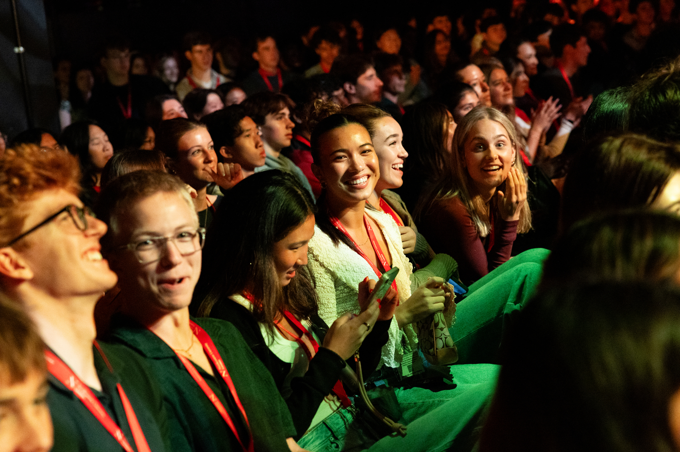 Students in the crowd at the London convocation smile. 