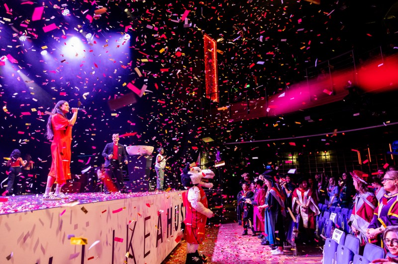 Students and Paws perform at convocation in London as confetti flies through the air.